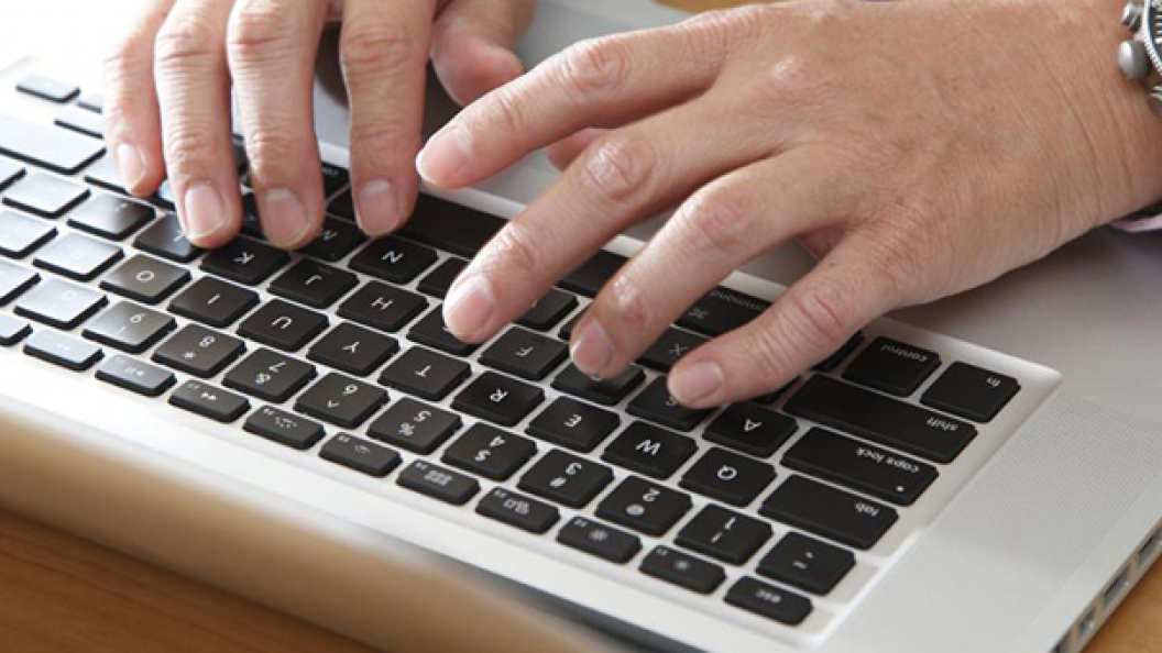 business-man-types-on-computer-keys
